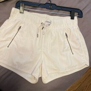 Athleta white shorts with zipper detail and subtle vertical stripes